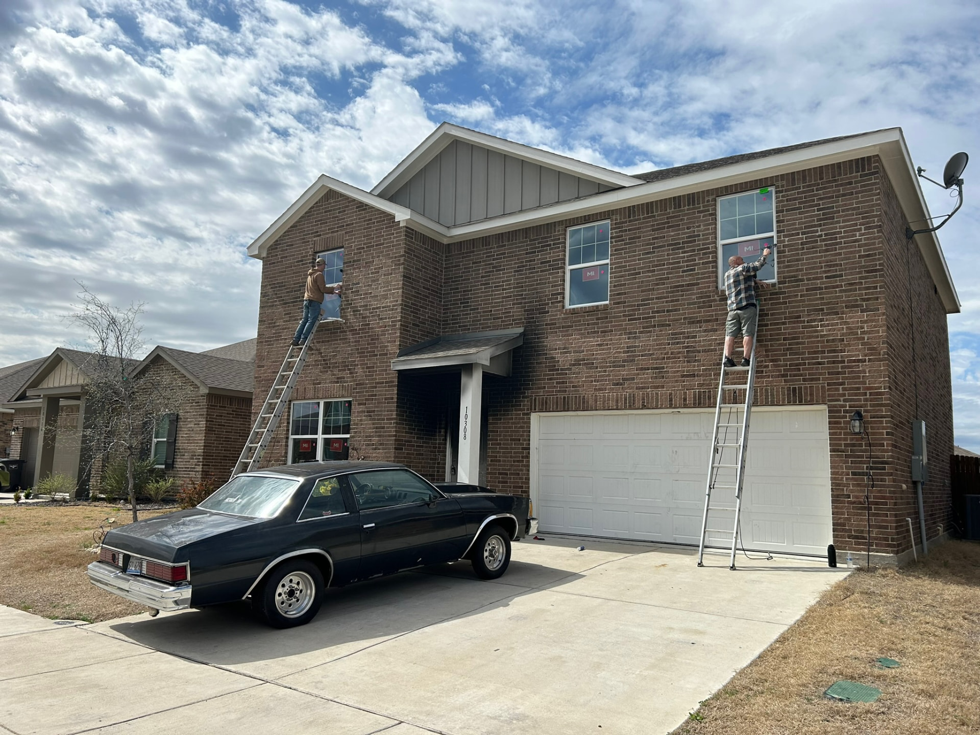ARWS installers fitting replacement windows on a two-story brick home in Dallas